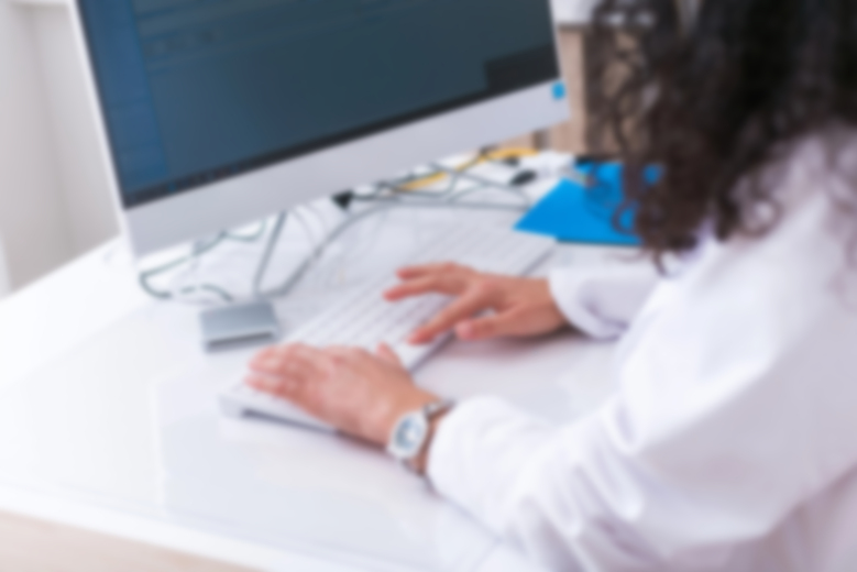 Nurse typing medical documents on computer