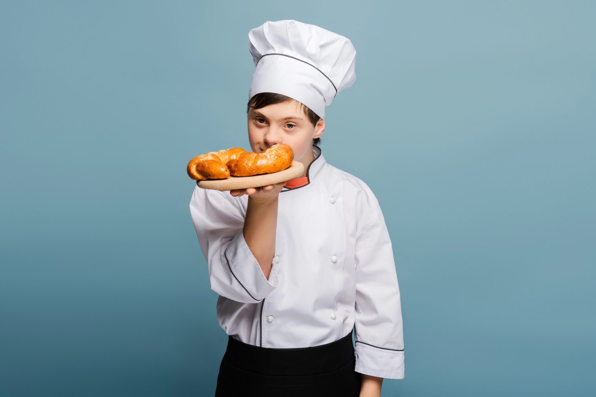 Down syndrome chef baker holding croissant