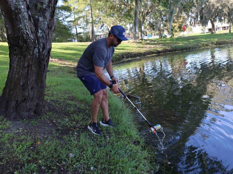 Ocala Mayor Ben Marciano picks up can from Lake Tuscawilla in Ocala on September 21, 2024