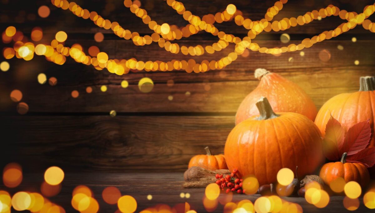 Composition with ripe pumpkins and autumn leaves on wooden table